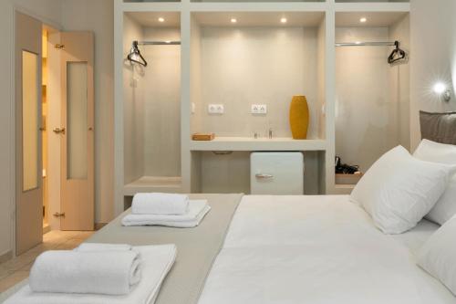 a bedroom with a large white bed and a sink at Artemida Beach House in Artemida