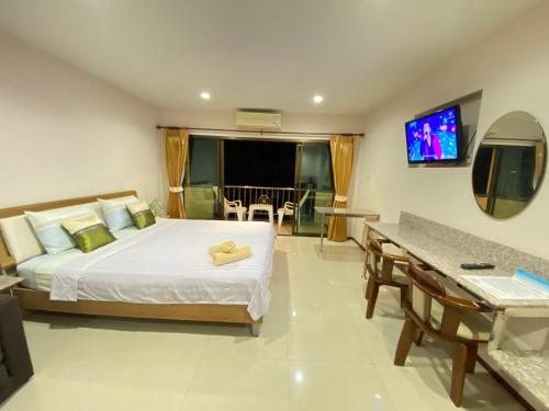 a bedroom with a bed and a television and a table at Dream Boutique Hotel in Cha Am