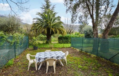 a table and chairs in a yard with a fence at 1 Bedroom Awesome Home In Vignale in Vignale