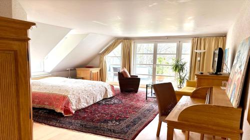a bedroom with a bed and a desk and a window at ArtVilla am See - offen März bis Ende Oktober in Radolfzell am Bodensee