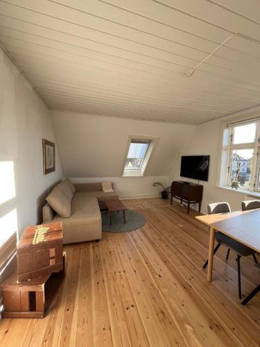 a living room with a couch and a table at Entire apartment in lovely villa in Odense