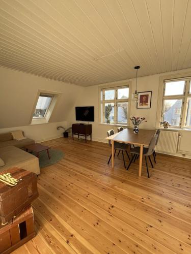 a living room with a table and a couch at Entire apartment in lovely villa in Odense