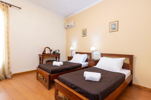 a room with two beds with white pillows at Hermes Xenon in Corfu Town