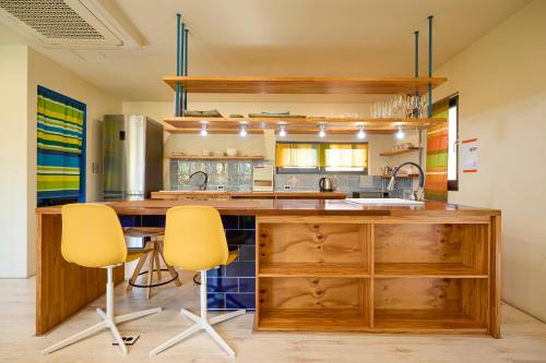 eine Küche mit einer großen Holzterrasse mit zwei gelben Stühlen in der Unterkunft Hongdae, Private Flats in Seoul