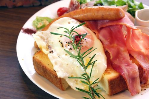 a plate of food with eggs and bread and vegetables at Shichi no Hotel in Hanabuchihama
