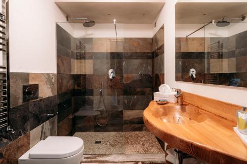 a bathroom with a shower and a toilet and a sink at Serendipity Hotel in Sauze dʼOulx