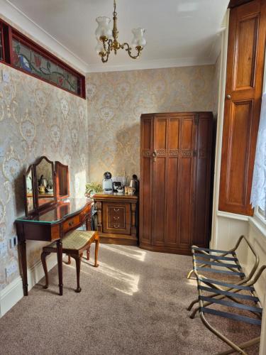 a room with a desk and a mirror and a cabinet at St David's Guesthouse in Haverfordwest