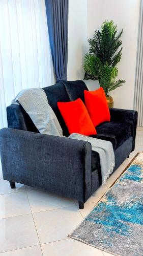 a blue couch with red pillows in a living room at 2 Bedroom Spacious Kampala Buwate Stay A few Steps from the Mall in Buwate