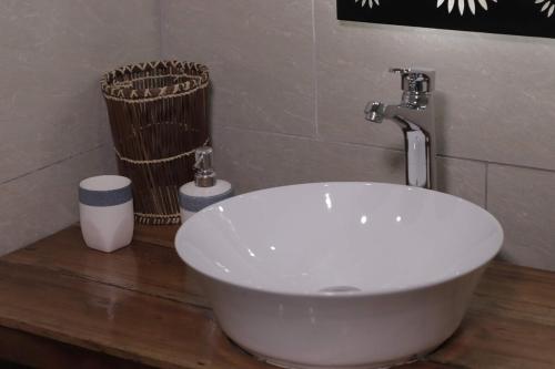 - une baignoire blanche assise sur un comptoir en bois dans la salle de bains dans l'établissement La Créole APT11, à Toamasina