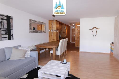 una sala de estar con un sofá y una mesa en Rothornblick 28 by Arosa Holiday, en Arosa