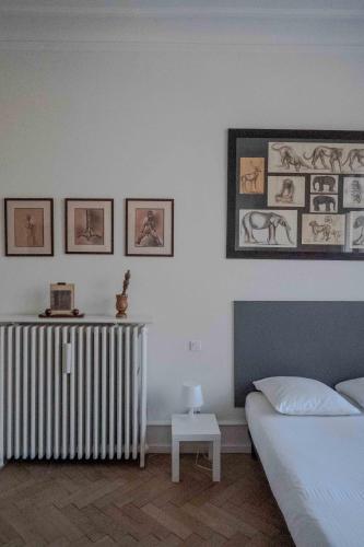 a bedroom with a bed and a radiator and pictures on the wall at Le Relais de l'Orangerie in Strasbourg