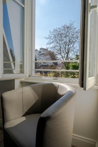 a leather chair in a room with a window at Le Relais de l'Orangerie in Strasbourg