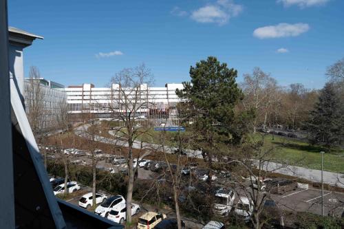 a parking lot with cars in front of a building at Le Relais de l'Orangerie in Strasbourg