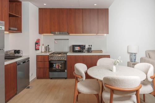 a kitchen with a table and chairs in a room at High-End Luxury 1BR in Port De La Mer near J1 Beachfront, Dubai in Dubai