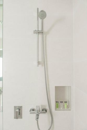a shower with a shower head in a bathroom at High-End Luxury 1BR in Port De La Mer near J1 Beachfront, Dubai in Dubai