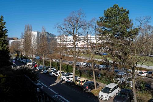a parking lot with cars parked in front of a building at Le Relais de l'Orangerie in Strasbourg