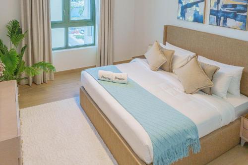 a bedroom with a bed with two towels on it at High-End Luxury 1BR in Port De La Mer near J1 Beachfront, Dubai in Dubai