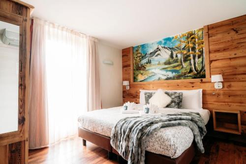 a bedroom with a bed and a painting on the wall at Serendipity Hotel in Sauze dʼOulx