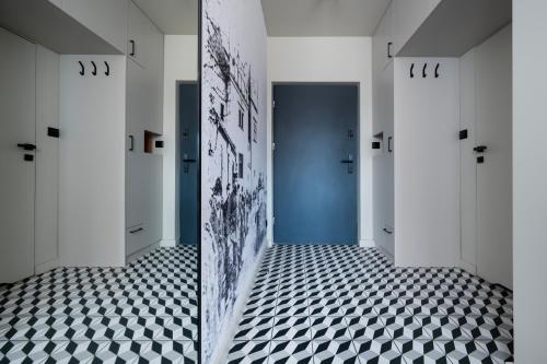 a hallway with a blue door and a checkered floor at Apartamenty Rocha in Pabianice