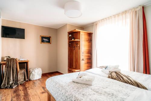 a bedroom with two beds and a window at Serendipity Hotel in Sauze dʼOulx