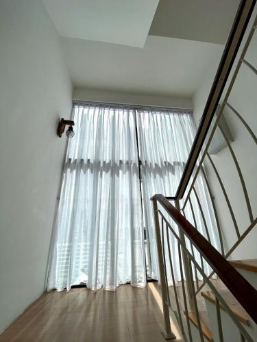 a room with a large window and a staircase at cc la villa in Kanching
