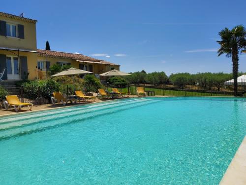 une piscine avec de l'eau bleue devant une maison dans l'établissement Mas du Barroux, à Le Barroux