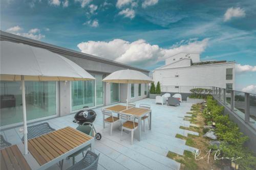 an outdoor deck with a table and chairs and a building at 500m2 Busan Ocean view private Let house in Busan