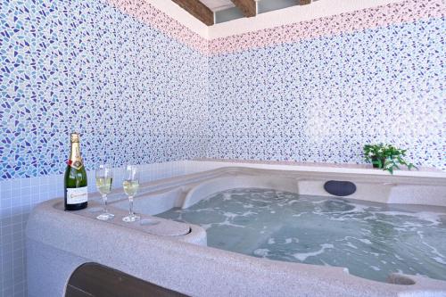 a bottle of wine and two wine glasses in a bath tub at Villa Alejandro En Sayalonga in Sayalonga