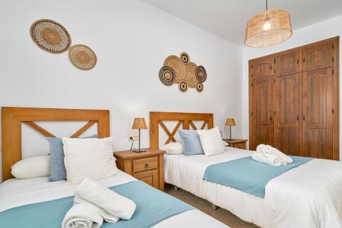 two beds in a room with white and blue at Villa Alejandro En Sayalonga in Sayalonga