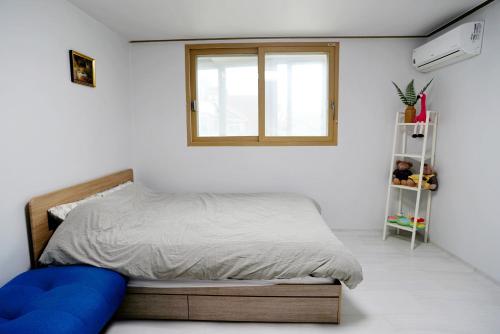a bedroom with a bed and a window at Cozy Home at Gangneung Central Market in Gangneung
