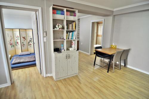 a living room with a table and a bedroom at Cozy Home at Gangneung Central Market in Gangneung