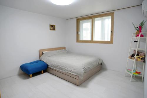 a small bedroom with a bed and a shelf at Cozy Home at Gangneung Central Market in Gangneung
