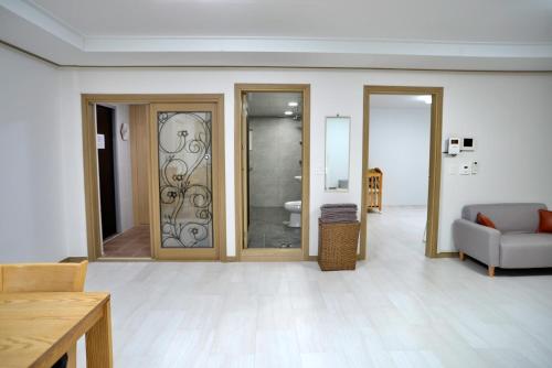 a living room with sliding glass doors and a couch at Cozy Home at Gangneung Central Market in Gangneung