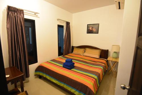Un dormitorio con una cama con una manta colorida. en Baan Peaceful Villa 2, Ao Nang, en Krabi