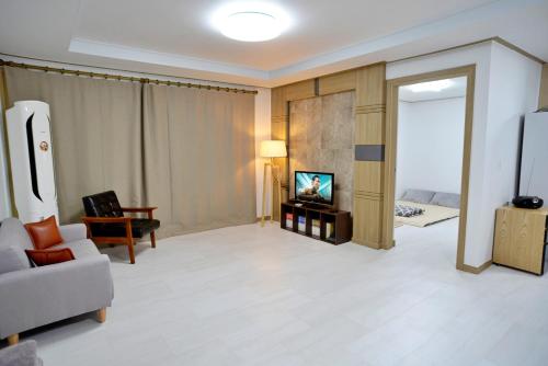 a living room with a couch and a tv at Cozy Home at Gangneung Central Market in Gangneung