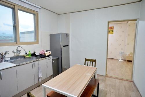 a kitchen with a table and a refrigerator at Cozy Home at Gangneung Central Market in Gangneung