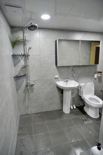 a bathroom with a toilet and a sink and a shower at Cozy Home at Gangneung Central Market in Gangneung