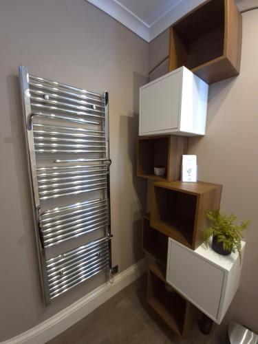a bathroom with a shower and a window with a shutter at St David's Guesthouse in Haverfordwest