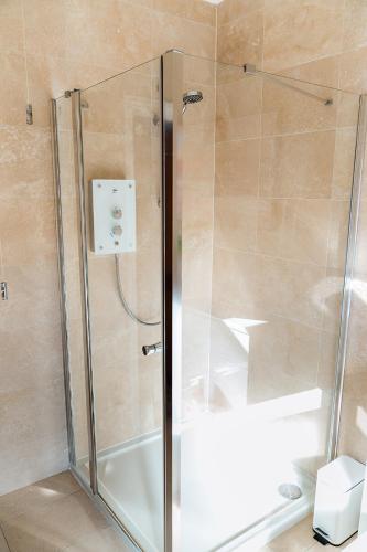 a shower with a glass door in a bathroom at Fairview House in Sheringham