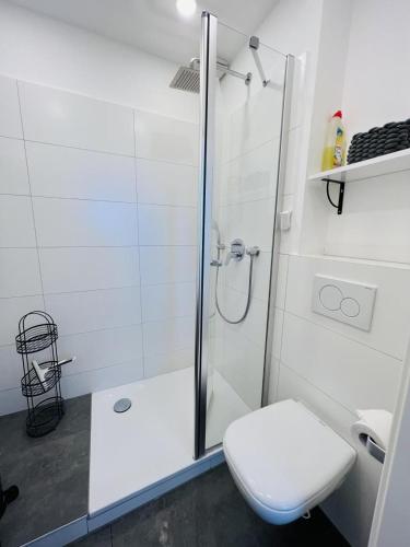 Un baño blanco con ducha y WC. en kleines Strandhus, en Scharbeutz