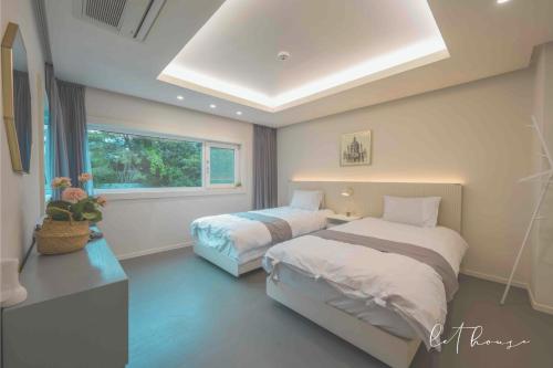 a bedroom with two beds and a window at 500m2 Busan Ocean view private Let house in Busan