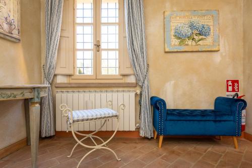 a living room with a blue chair and a window at San Giovanni Residence in Peccioli