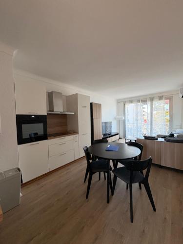 un salon avec une table et des chaises et une cuisine dans l'établissement Studio bord de plage - vue mer, à Argelès-sur-Mer