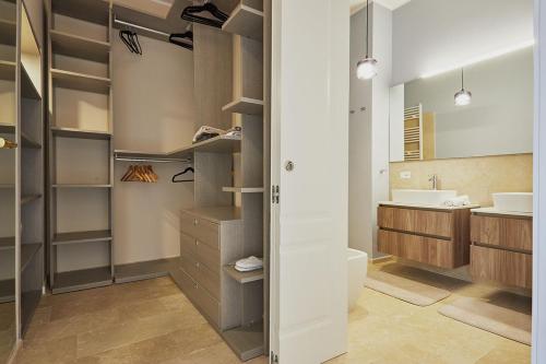 a bathroom with a walk in closet and a sink at Aurispa 143 con piscina Noto centro in Noto