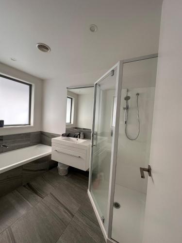a bathroom with a shower and a sink at Easy Beach Holiday in Mount Maunganui