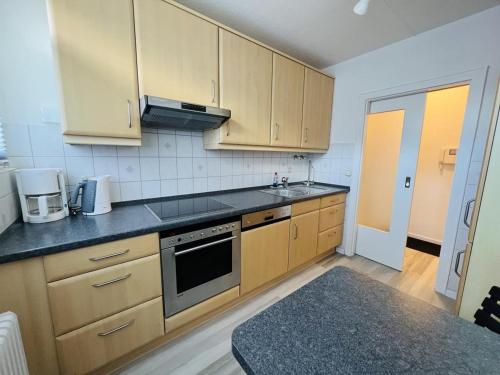 a kitchen with wooden cabinets and a stove top oven at Zur Seeschwalbe in Scharbeutz