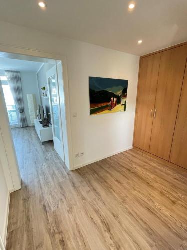a living room with wooden floors and a painting on the wall at Nellie´s Nest in Scharbeutz