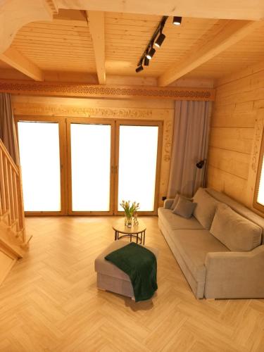 a living room with a couch and some windows at Domek z bali Zakopane in Zakopane