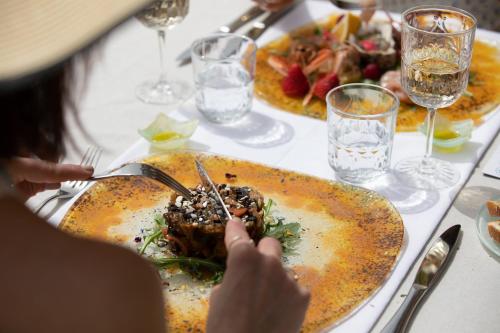 a person sitting at a table with a plate of food at Aurispa 143 con piscina Noto centro in Noto