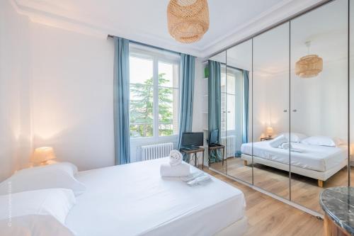une chambre avec un lit blanc et un miroir dans l'établissement Appartement - Roland-Garros & Parc des Princes, à Boulogne-Billancourt
